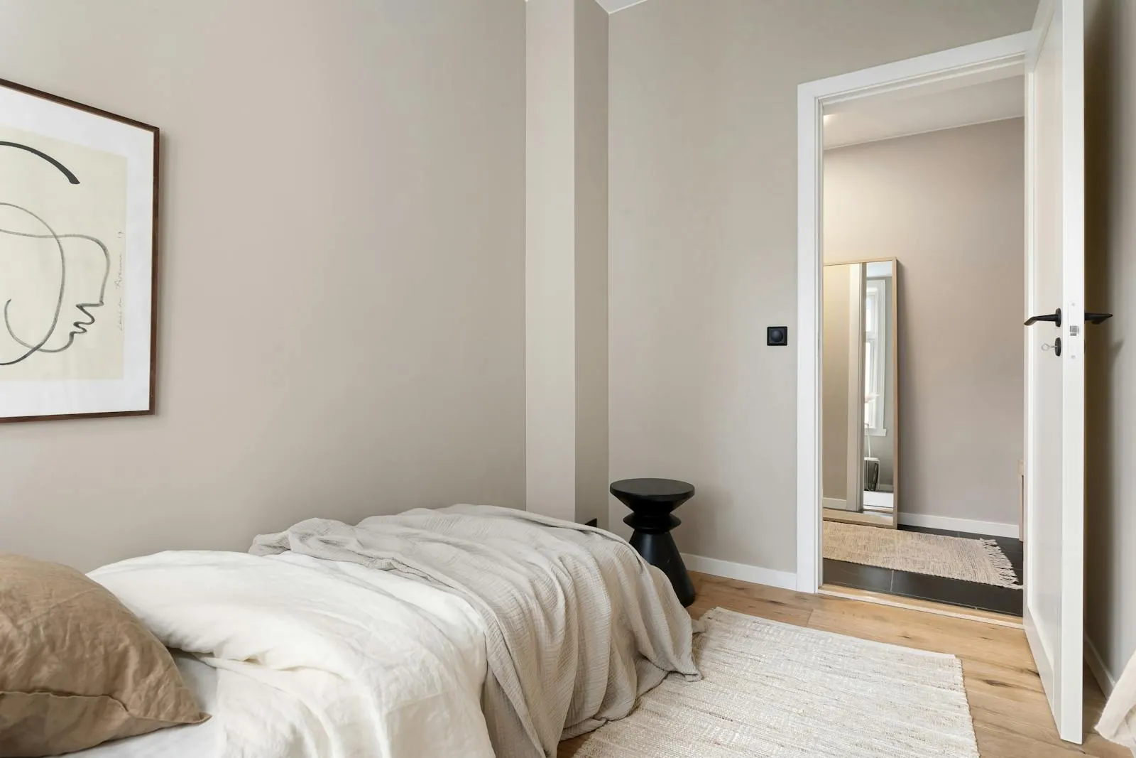 Kleines, ruhig eingerichtetes Schlafzimmer mit Bett an der Wand