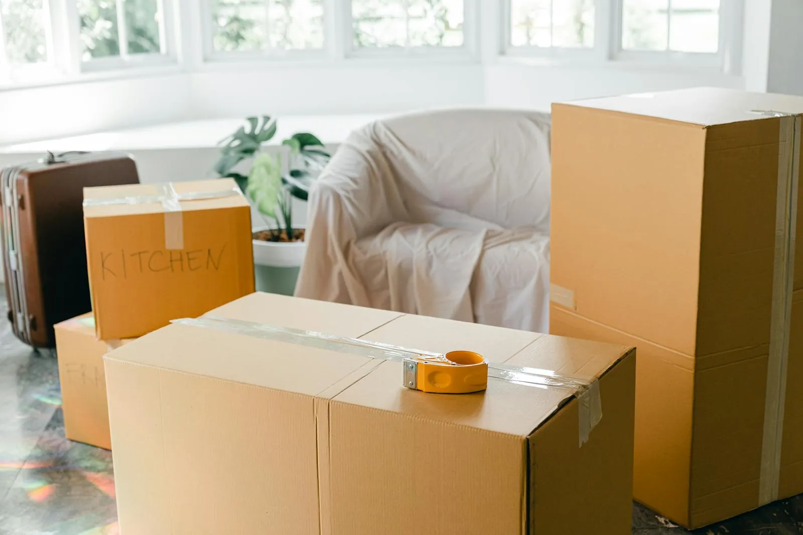 Umzugskartons in einer hellen Erstmieter-Wohnung mit Sessel